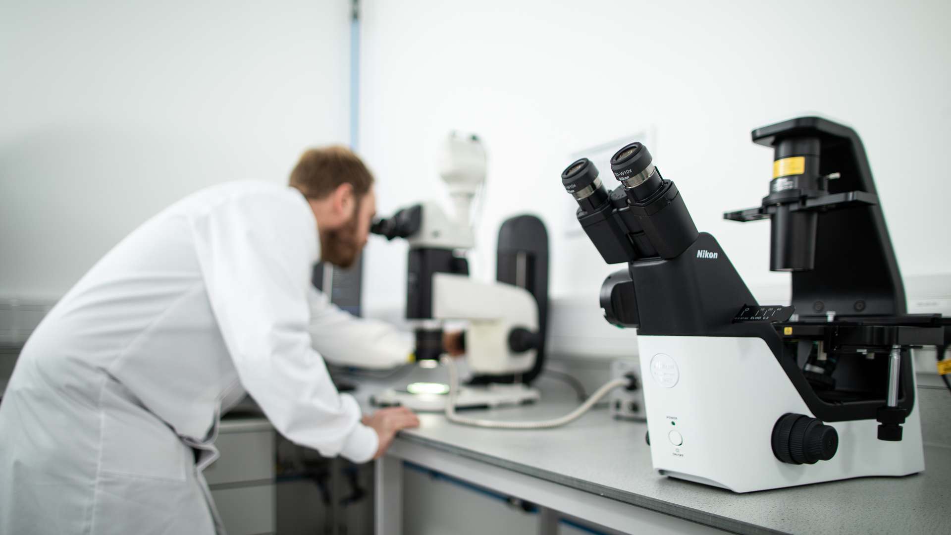Scientist looking into a microscope Scientist looking into a microscope
