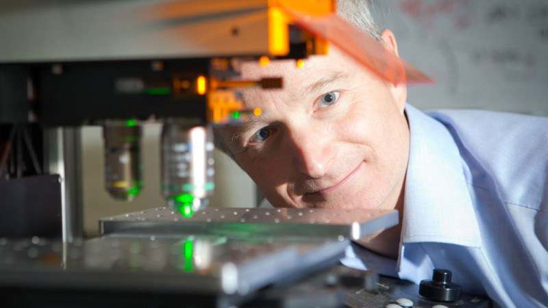 A photo of a person stood next to a photon laser. A photo of a person stood next to a photon laser.