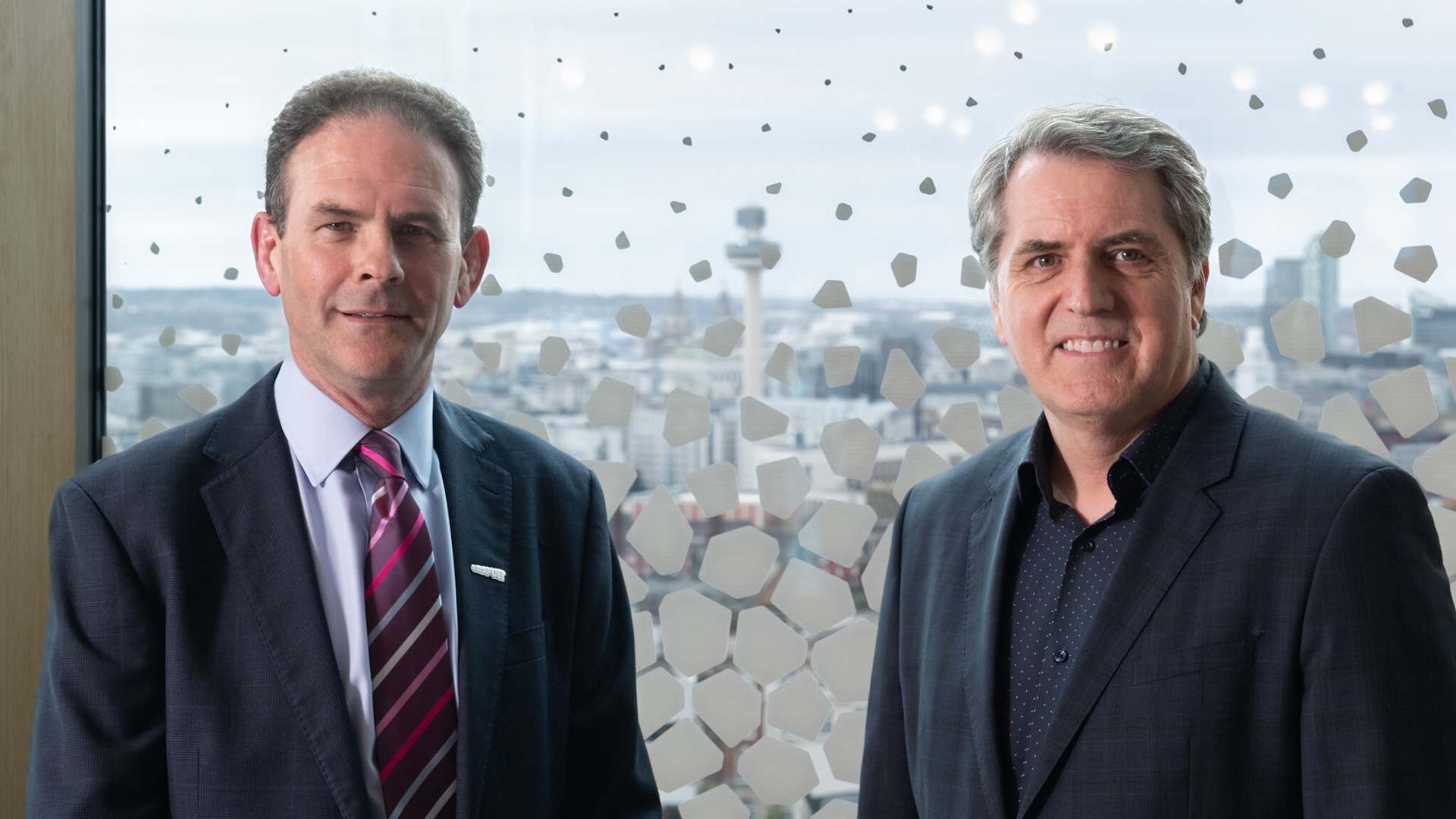 Our CEO, Frank Millar, standing next to the Metro Mayor of the Liverpool City Region, Steve Rotheram, in front of a window in The Spine building in Liverpool Science Park that overlooks the City of Liverpool's skyline. Our CEO, Frank Millar, standing next to the Metro Mayor of the Liverpool City Region, Steve Rotheram, in front of a window in The Spine building in Liverpool Science Park that overlooks the City of Liverpool's skyline.