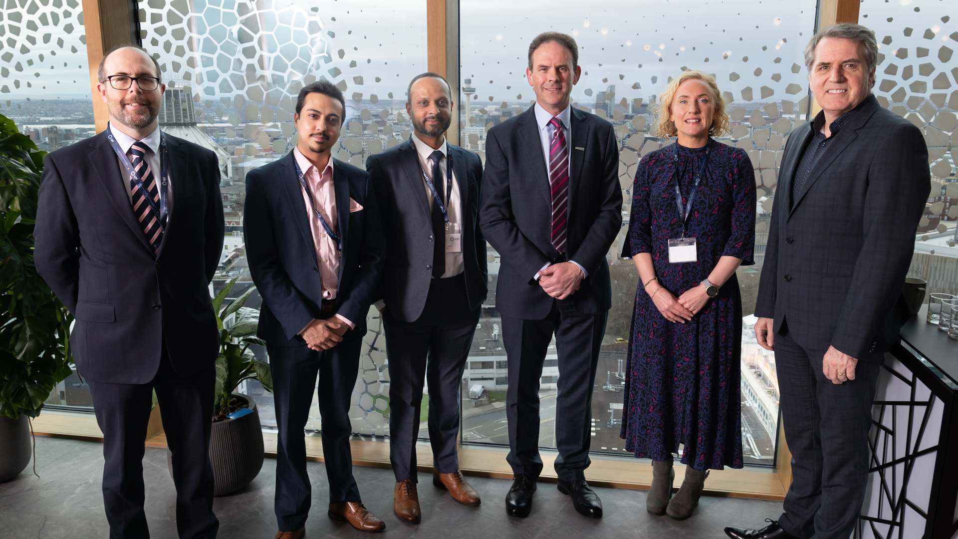 A photo of Steve Mcbride (Head of KCMC at CPI), Damian Mohammed (Strategic Partnerships Manager at CPI), Arun Harish (Director of Strategy at CPI), Frank Millar, Sophie Walton, and Steve Rotheram standing in front of a window overlooking the Liverpool skyline in The Spine building at Liverpool Science Park A photo of Steve Mcbride (Head of KCMC at CPI), Damian Mohammed (Strategic Partnerships Manager at CPI), Arun Harish (Director of Strategy at CPI), Frank Millar, Sophie Walton, and Steve Rotheram standing in front of a window overlooking the Liverpool skyline in The Spine building at Liverpool Science Park