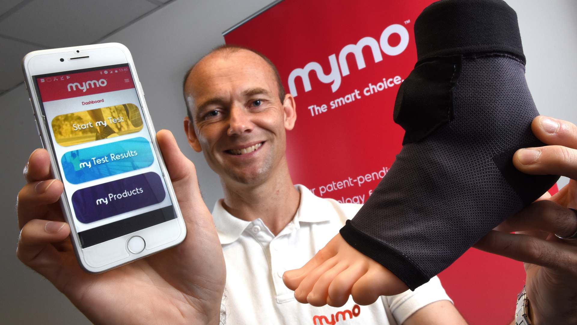 Mr Downs is pictured with a wearable sock that uses artificial intelligence to monitor a runner’s gait before sending the information to a smartphone Mr Downs is pictured with a wearable sock that uses artificial intelligence to monitor a runner’s gait before sending the information to a smartphone