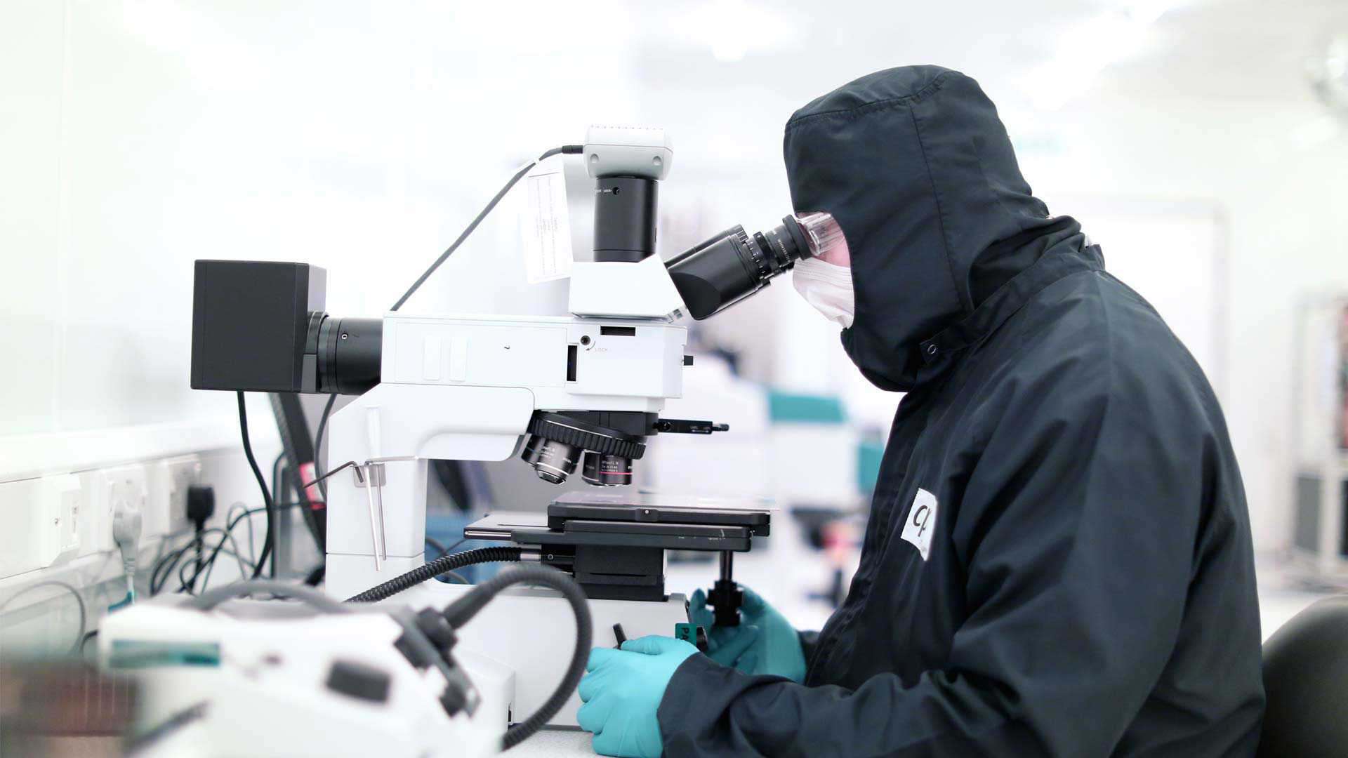 A man using a microscope in a lab A man using a microscope in a lab